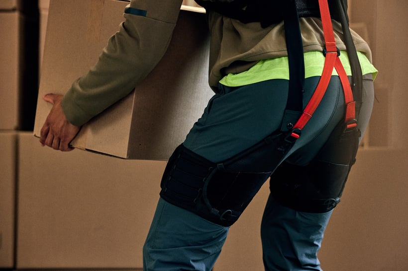 A worker lifting with the powered SafeLift exosuit.